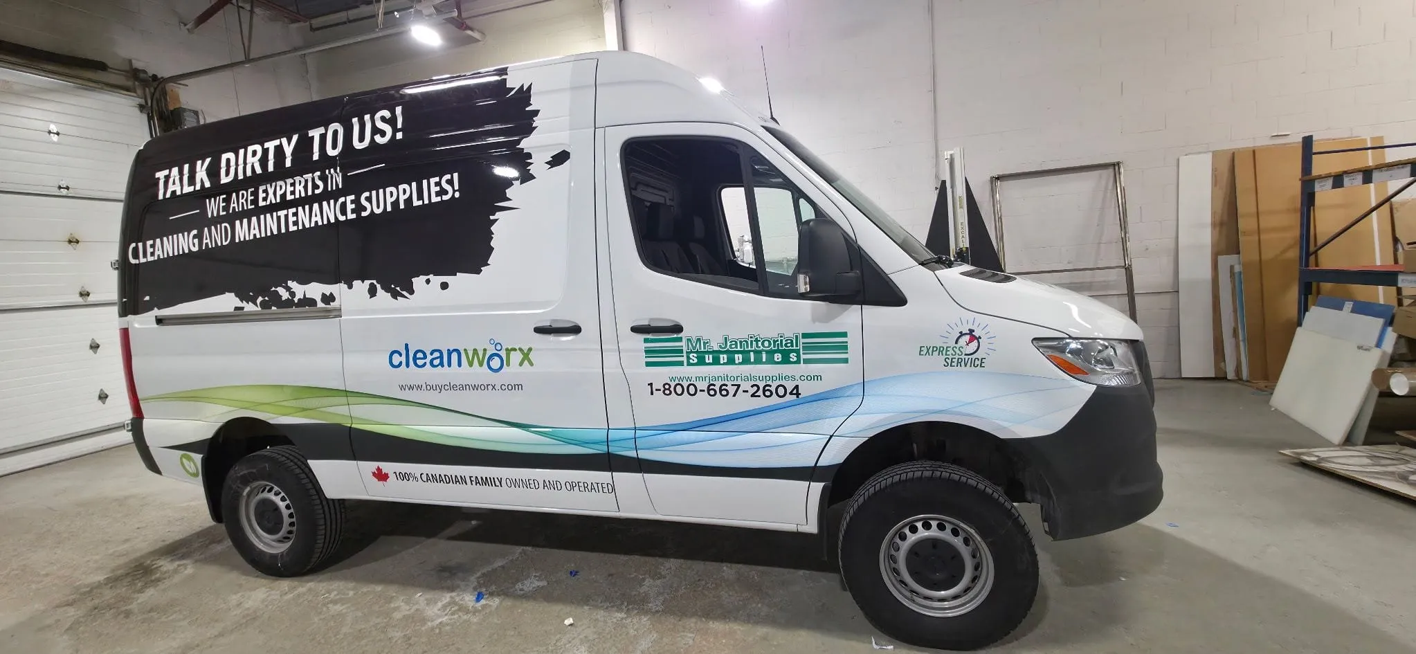 White Cleanworx Sprinter van with full-side cleaning-supplies graphics, in the shop