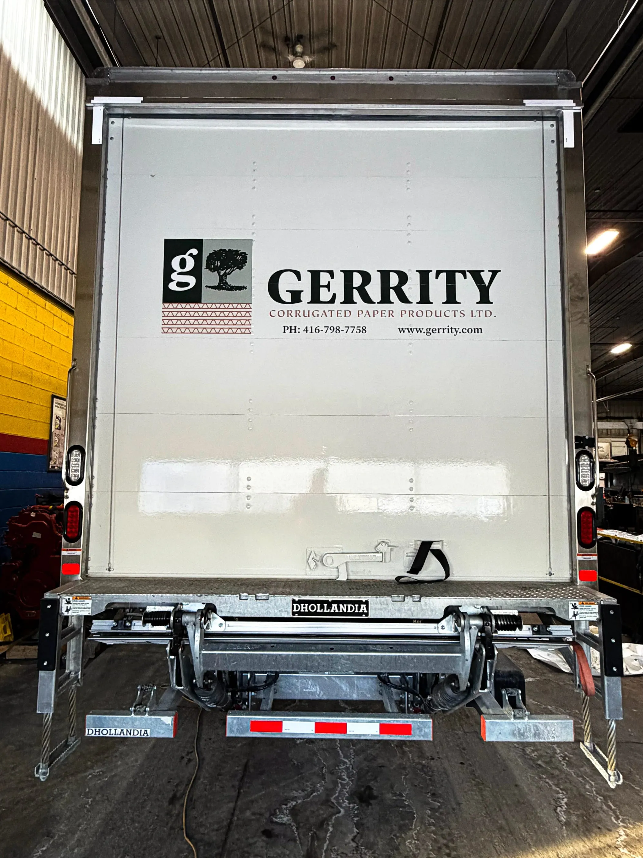Rear door of a white box truck with Gerrity company graphics, in the shop