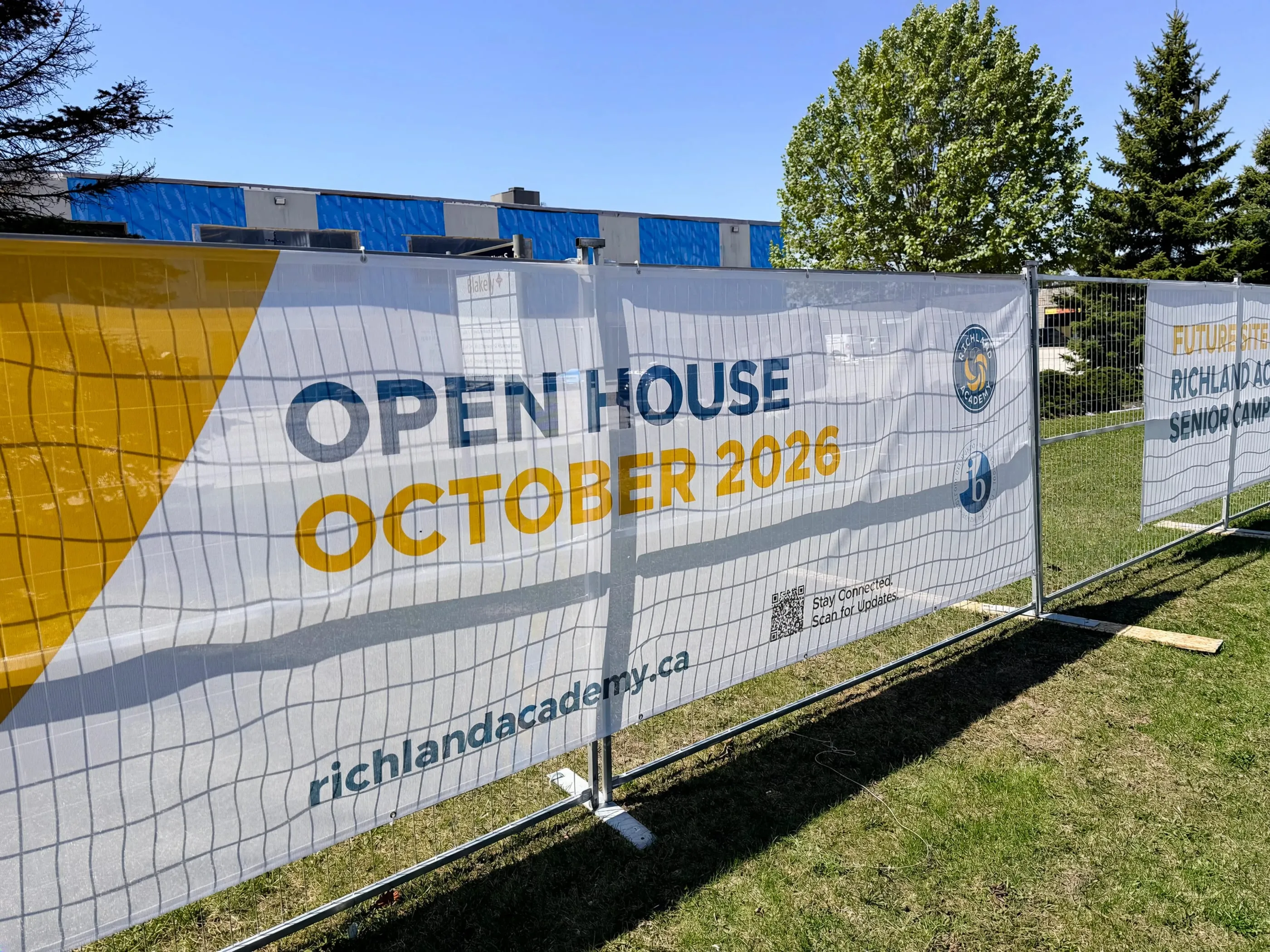 “Open House October 2026” banner installed on a construction fence